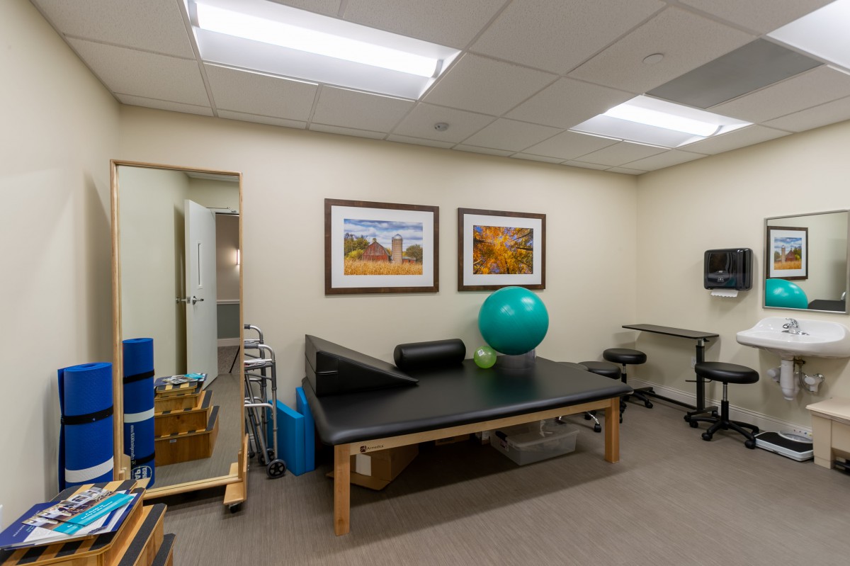 A physical therapy room equipped with exercise tools and a treatment table.