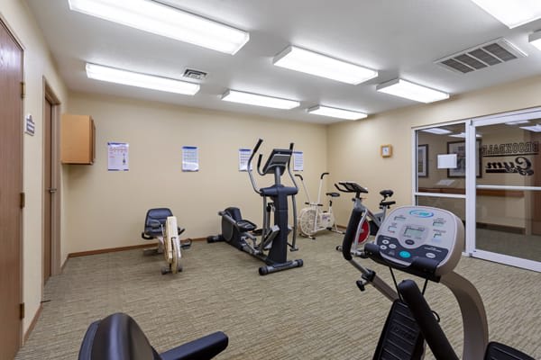 A small indoor gym with various exercise equipment including stationary bikes and a treadmill.