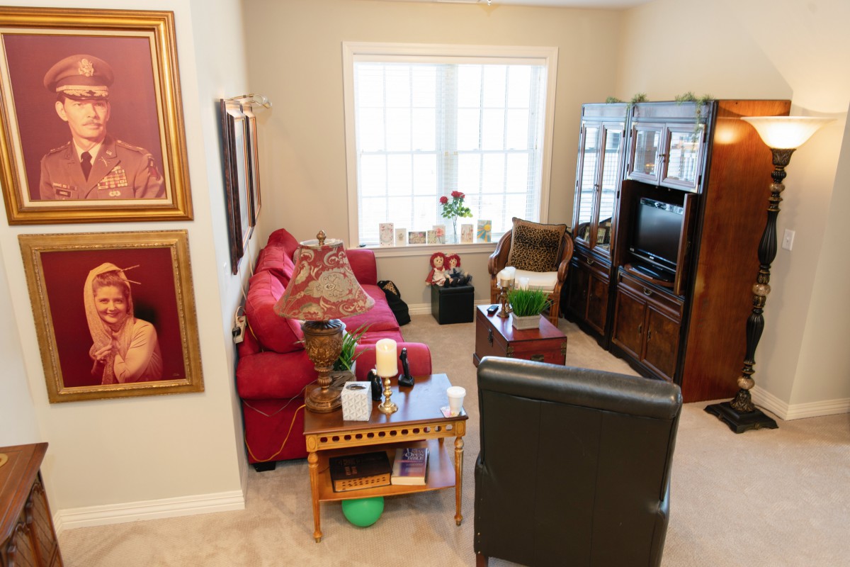 A cozy living room with a red sofa, chairs, and a television.