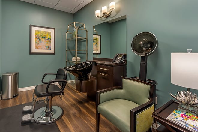 A cozy hair salon interior with chairs, a sink, and stylish decor.