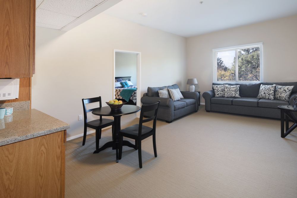 A spacious living room with modern furniture, including two sofas and a dining table set.