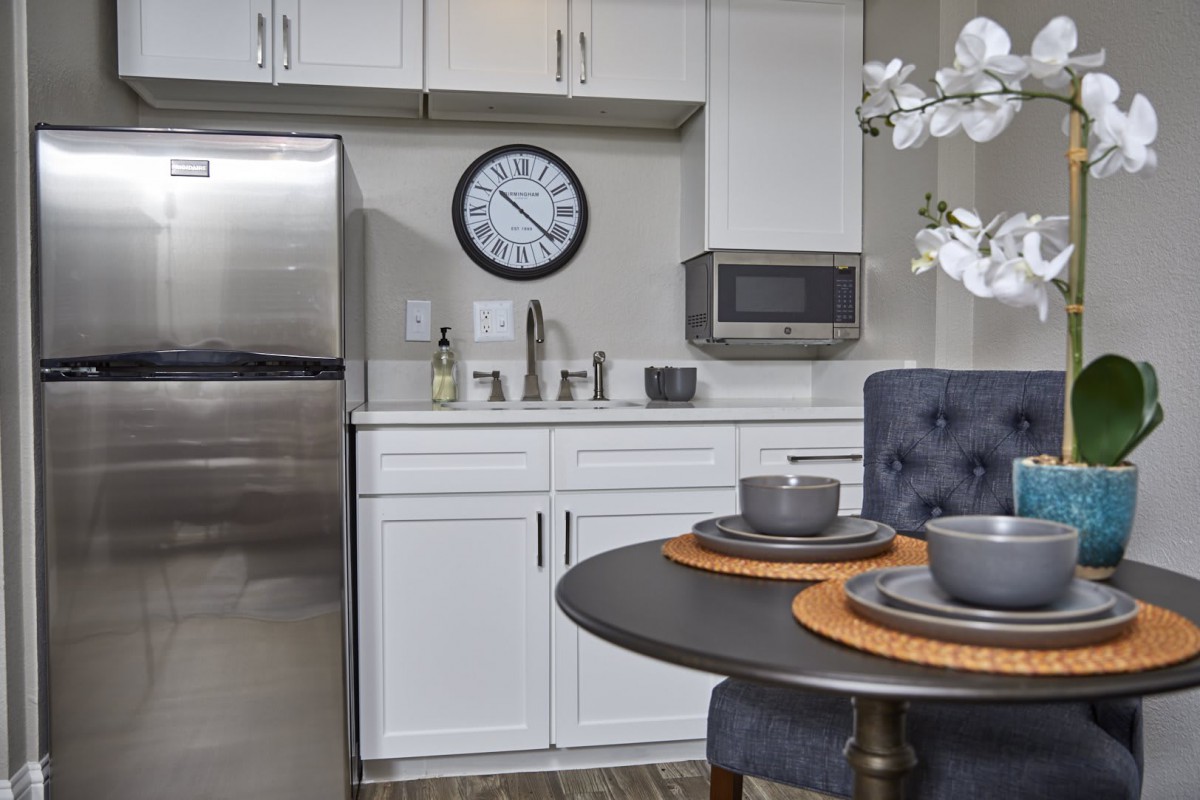 A modern kitchen interior with a dining table set for two.
