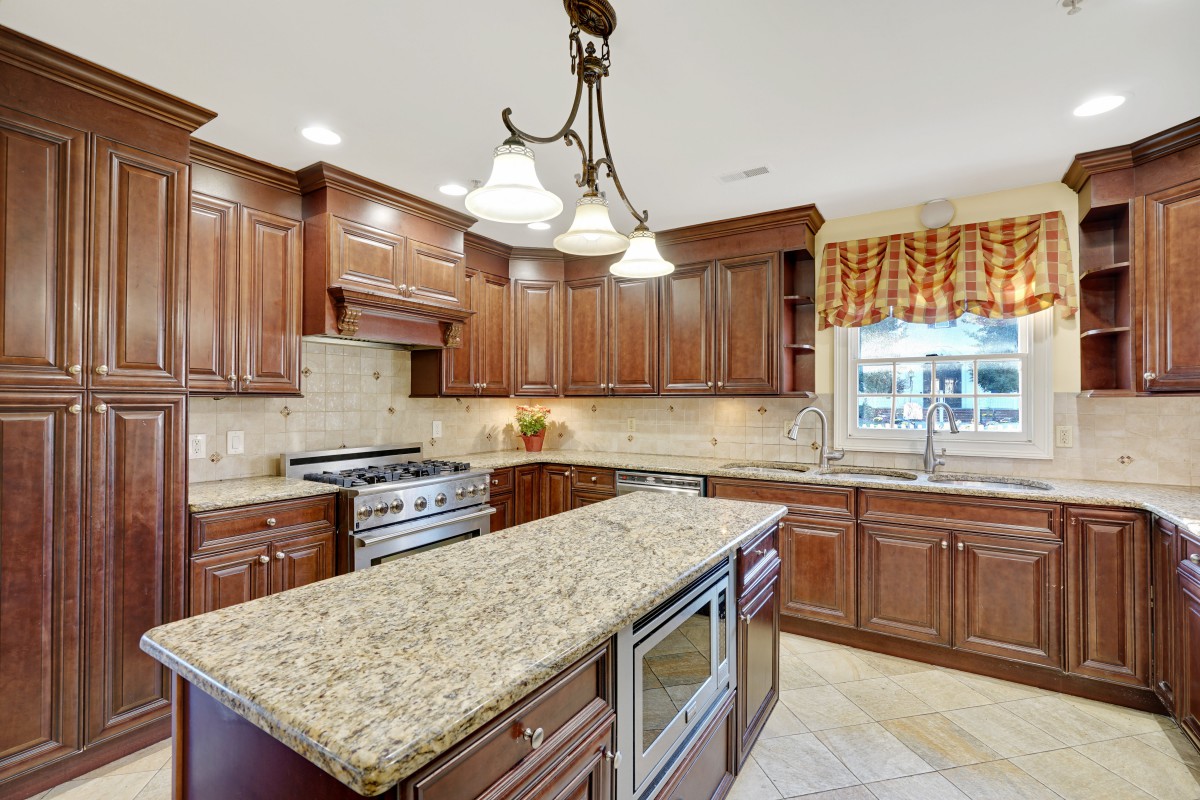 A modern kitchen with wooden cabinets and a granite countertop island.