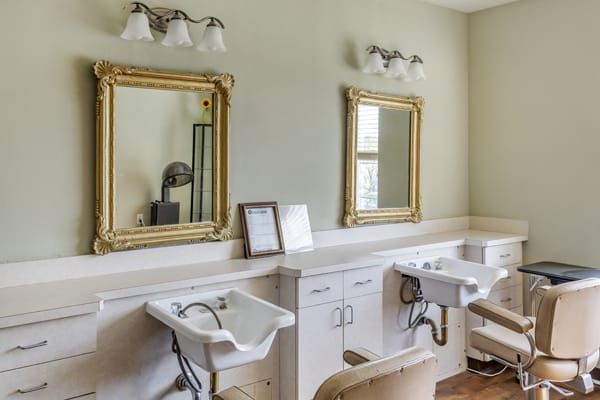 An elegantly designed hair salon setup with mirrors and sink stations.