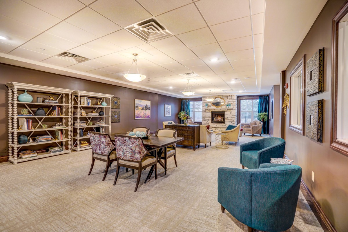 A cozy and well-furnished lounge area with bookshelves and comfortable seating.