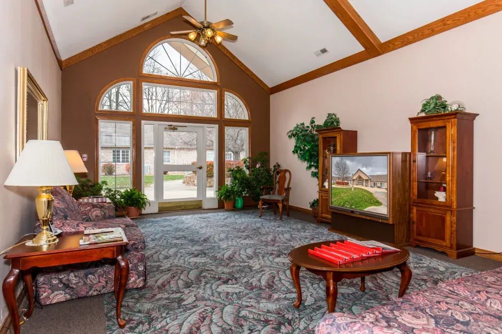A cozy lobby featuring comfortable furniture, large windows, and decorative plants.