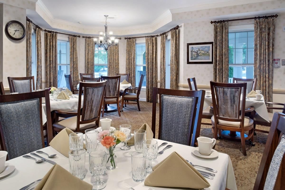 An elegant dining room with well-set tables and a chandelier.