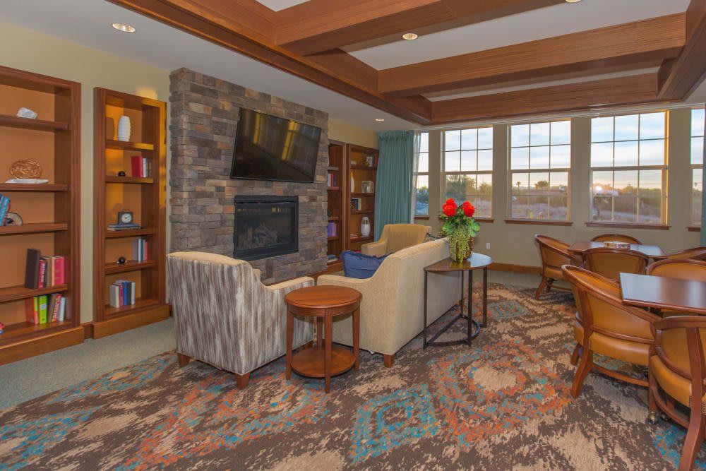 A cozy living room with a fireplace, television, and bookshelves.