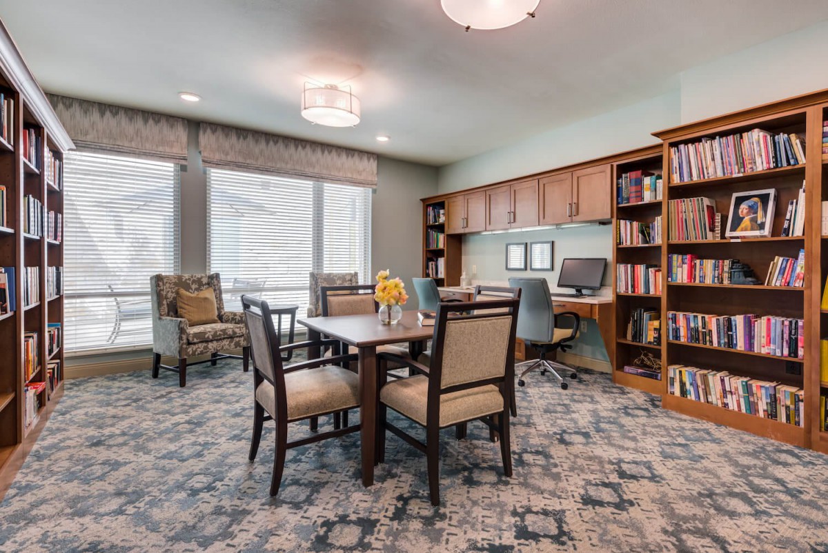 A well-organized office space featuring a desk, chairs, bookshelves, and a computer.