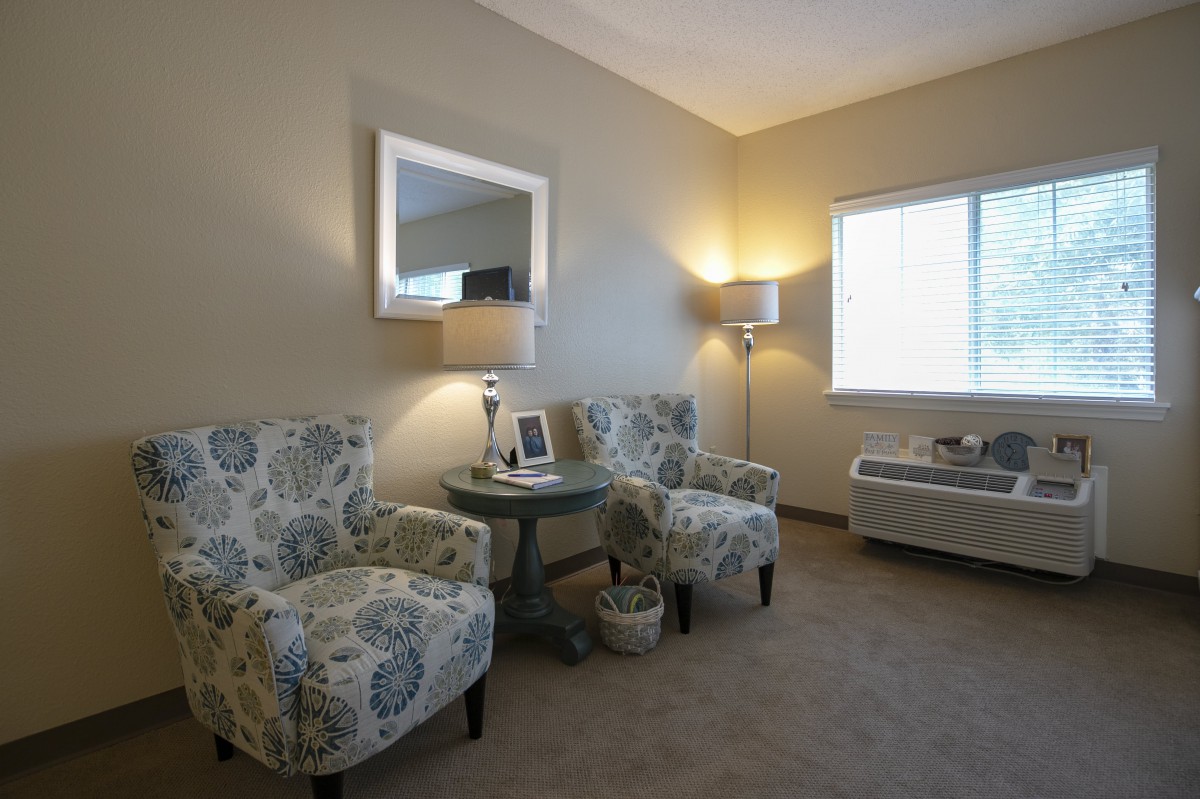 A cozy living room with patterned chairs and a warm ambiance.