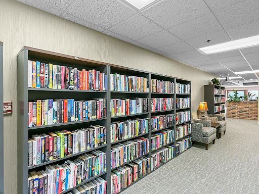 A well-organized library featuring shelves filled with a variety of books, creating an inviting reading atmosphere.