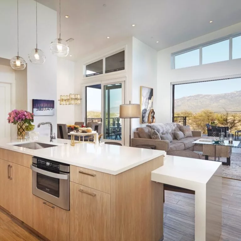 A modern open concept kitchen and living area with ample natural light and scenic views.