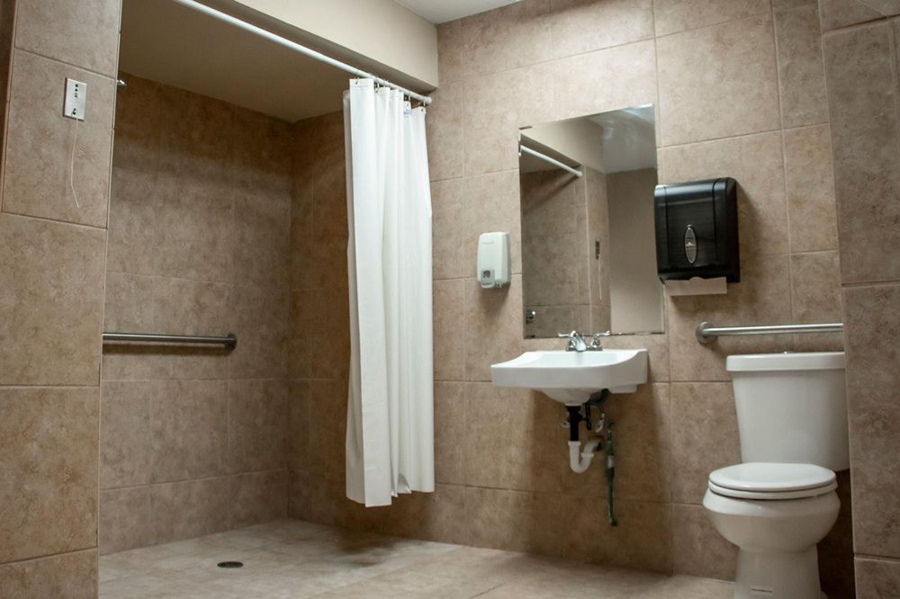 An accessible bathroom with a sink, toilet, and shower area.