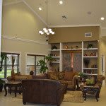 A spacious living room with elegant furniture, well-organized shelves, and tasteful decor.