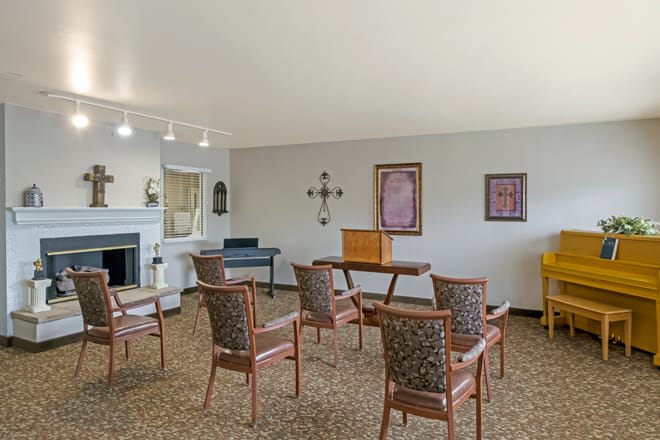 A small meeting room with arranged chairs and decorative artwork on the walls.
