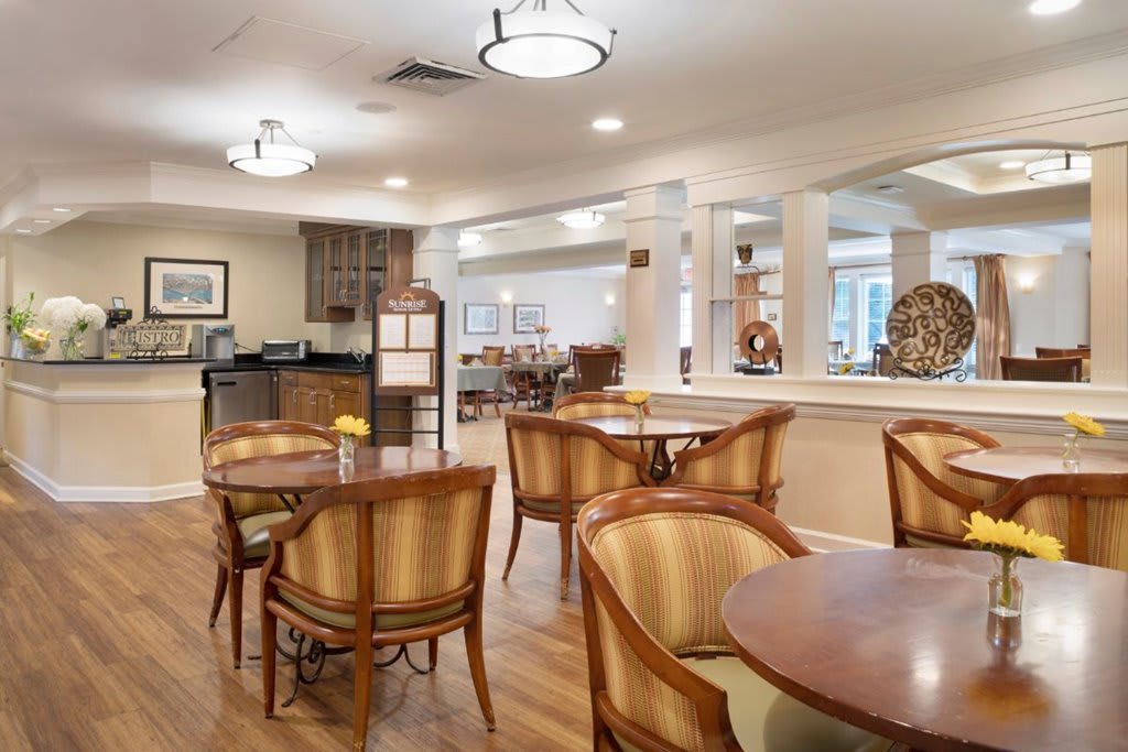 A well-lit dining area with wooden chairs and tables in a restaurant setting.