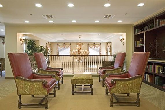 A luxurious indoor lounge area with comfortable chairs and a chandelier.