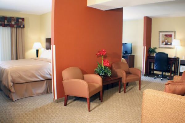 A cozy hotel room featuring comfortable seating and a dividing wall.