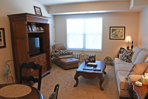 A cozy living room setup featuring a comfortable sofa, a coffee table, and ample natural light from the window.