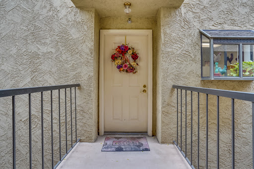 A welcoming entrance featuring a decorative wreath and a cozy welcome mat.