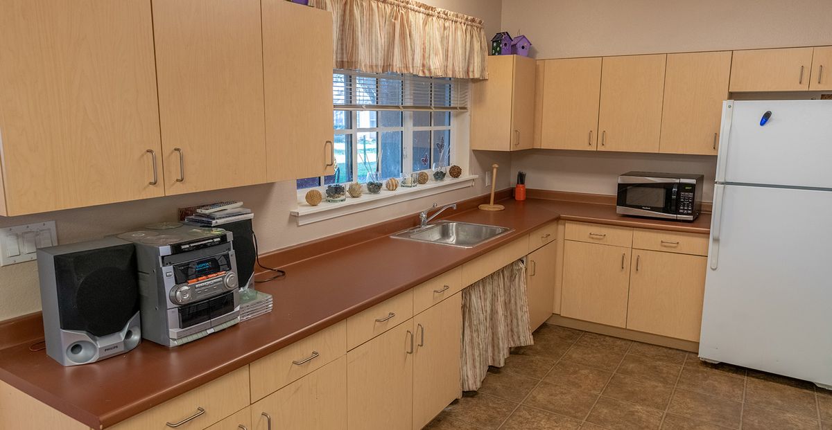A cozy kitchen with light-colored cabinets and a window above the sink.