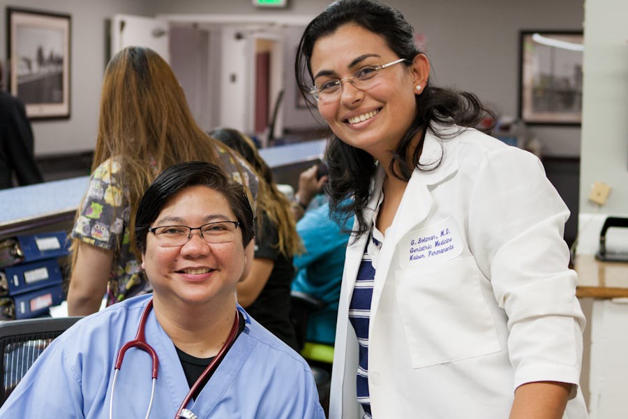 Two healthcare professionals smiling in a medical setting.
