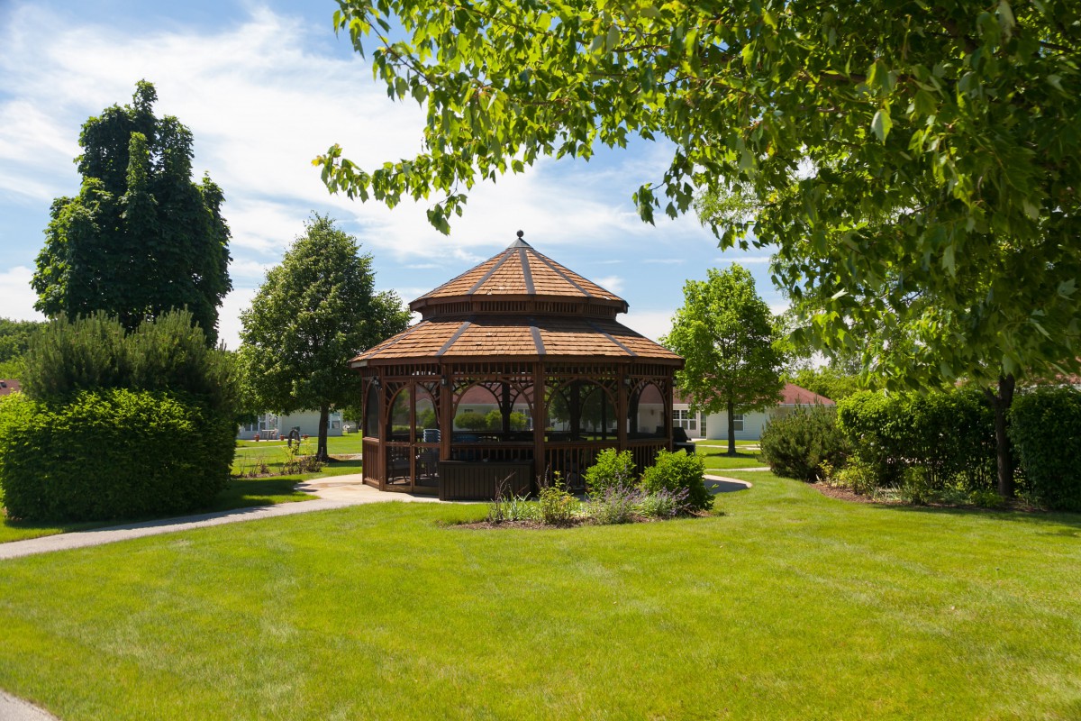 A picturesque gazebo surrounded by lush greenery in a serene park setting.