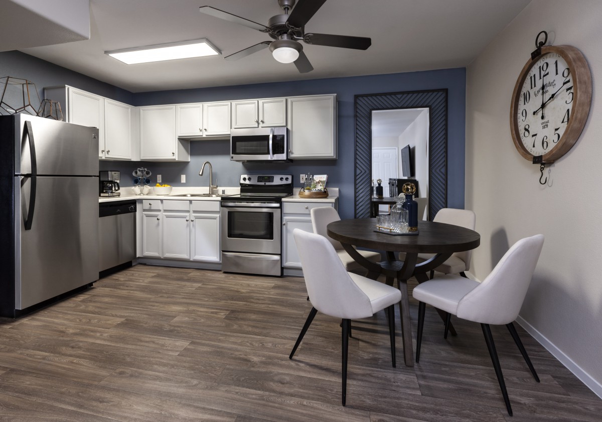 A modern kitchen and dining area with stainless steel appliances and chic furnishings.