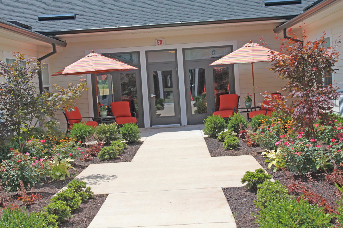 A well-maintained patio area with comfortable seating, umbrellas, and vibrant landscaping.
