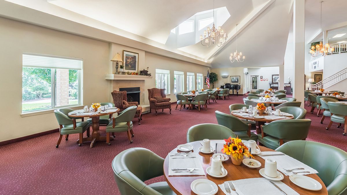Brightly lit dining room with neatly arranged tables and chairs.