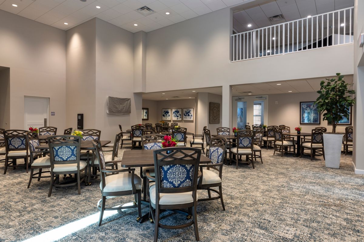 A modern dining area with neatly arranged tables and chairs, featuring elegant decor.