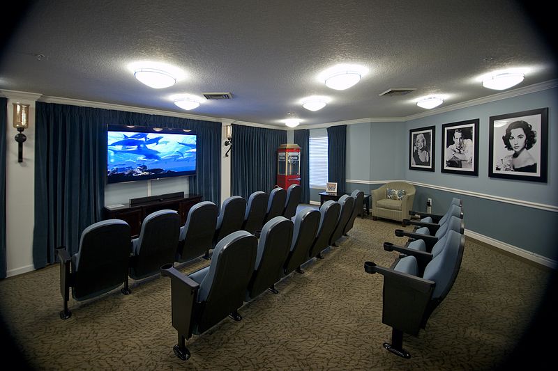 A cozy home theater setup with rows of seating and a large screen for viewing.