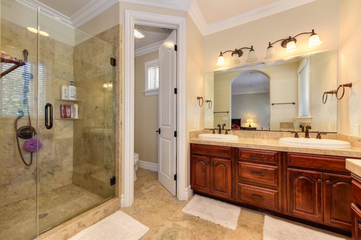 Elegant bathroom featuring a glass-enclosed shower and double vanity sinks.