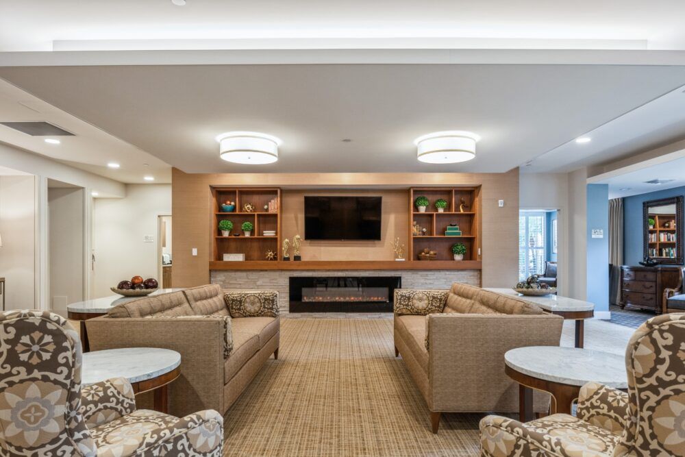 A modern living room with comfortable sofas, a wall-mounted television, and stylish shelving.