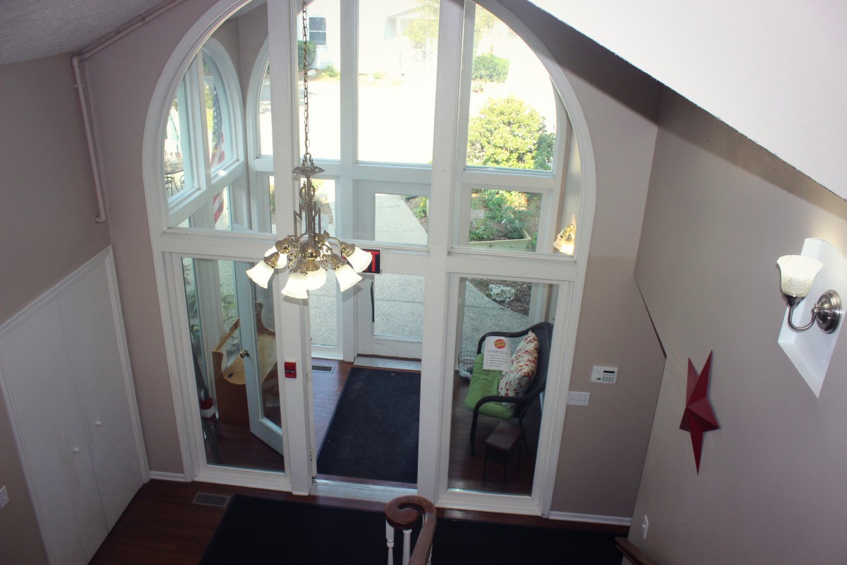 Interior view of a lobby with glass doors and a chandelier.