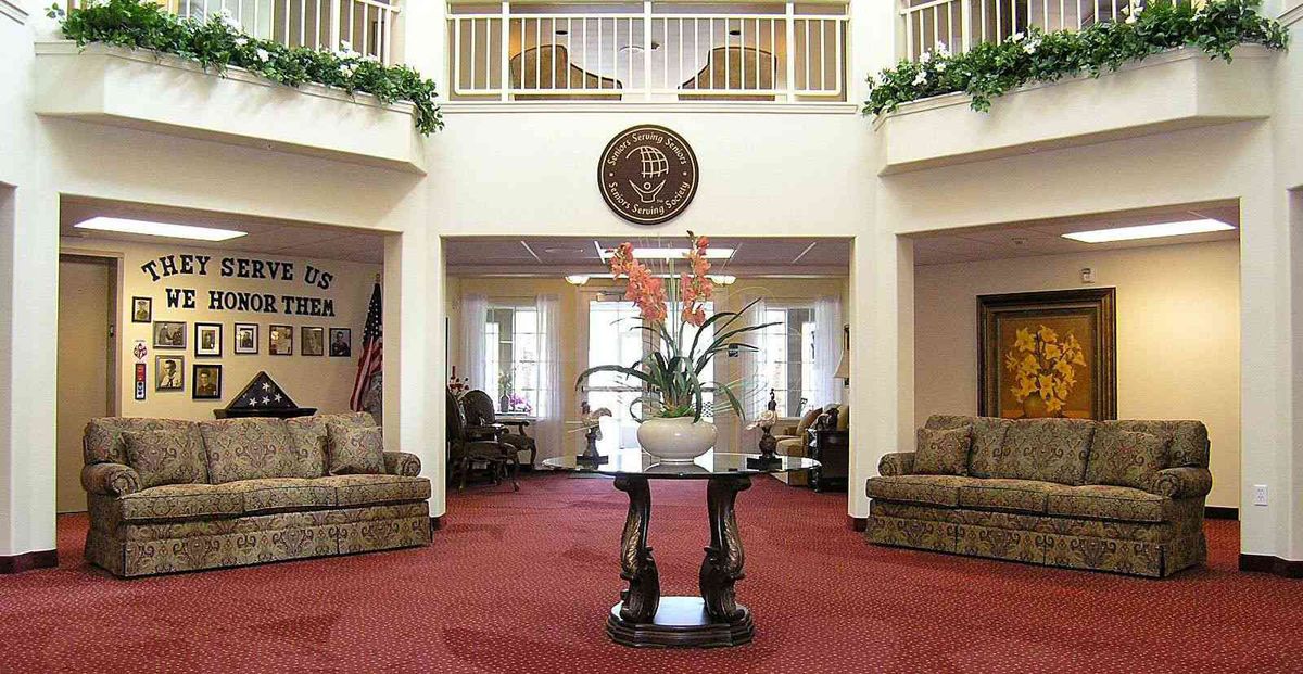 A well-decorated lobby with comfortable seating and a central floral arrangement.