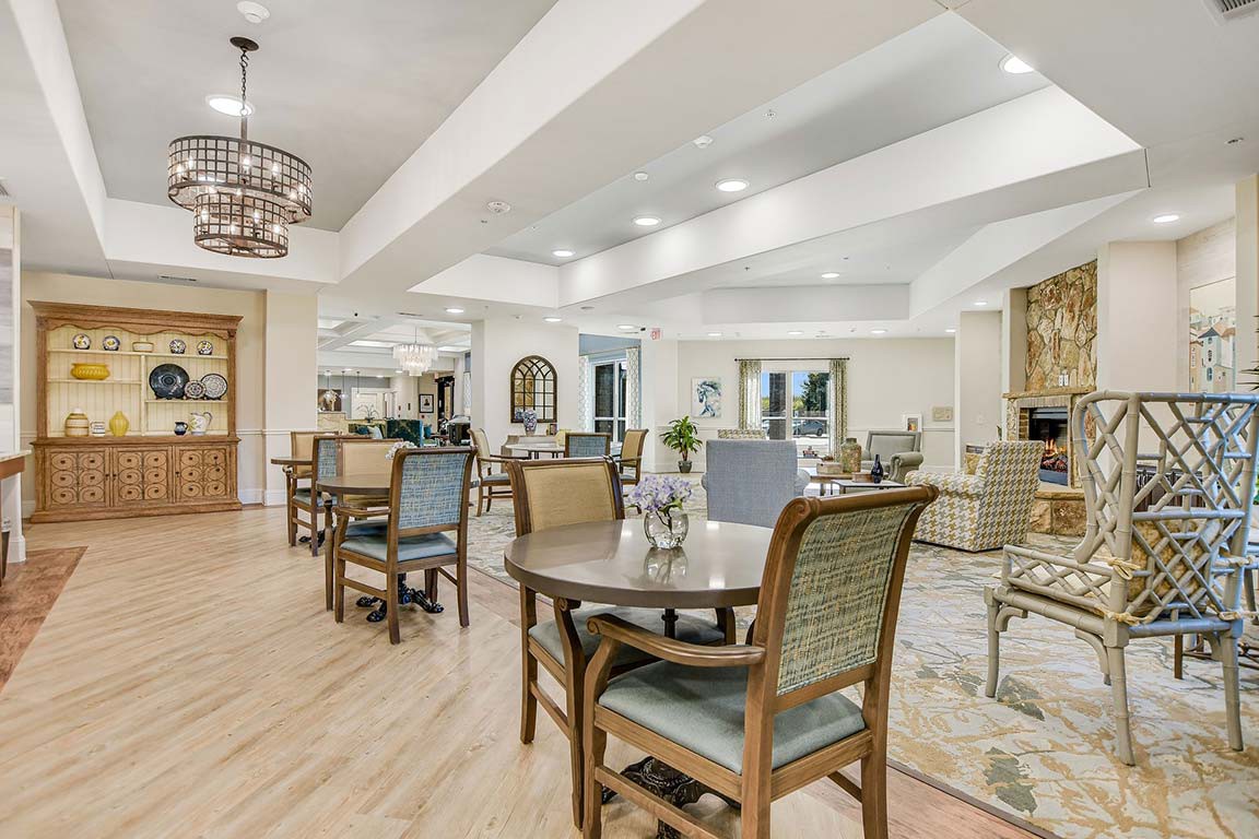 A well-lit and elegantly furnished dining area with several tables and chairs, featuring modern decor and design elements.