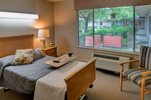 A cozy bedroom with a view of greenery outside the window.