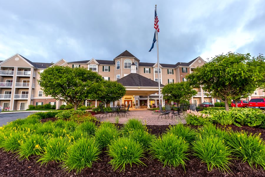 A scenic outdoor view of a hotel surrounded by lush greenery and an American flag waving in front.