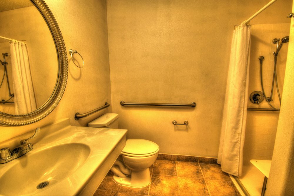 A bathroom with a sink, toilet, and shower curtain.