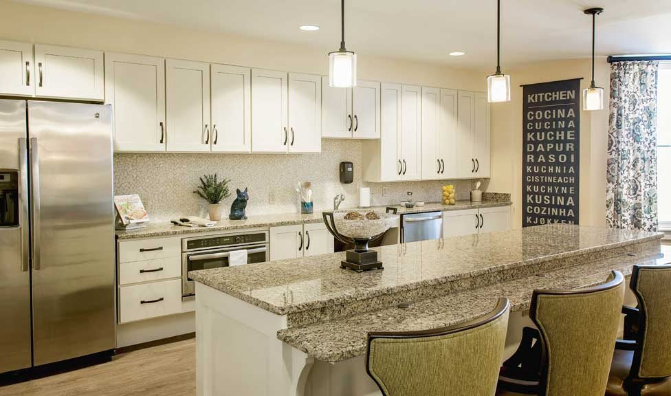 Modern kitchen with a granite countertop and stylish pendant lighting.