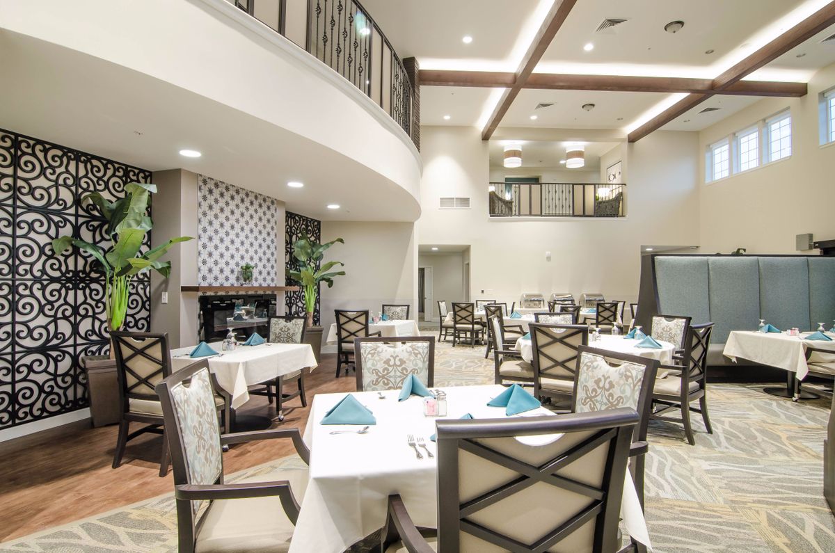 An elegant dining room with neatly arranged tables and chairs, featuring stylish interior design and warm lighting.