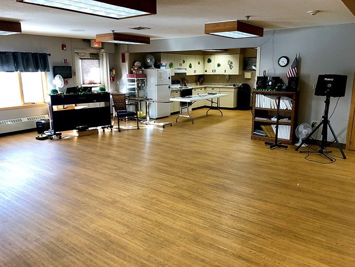 Spacious room with a kitchen area and wooden flooring.
