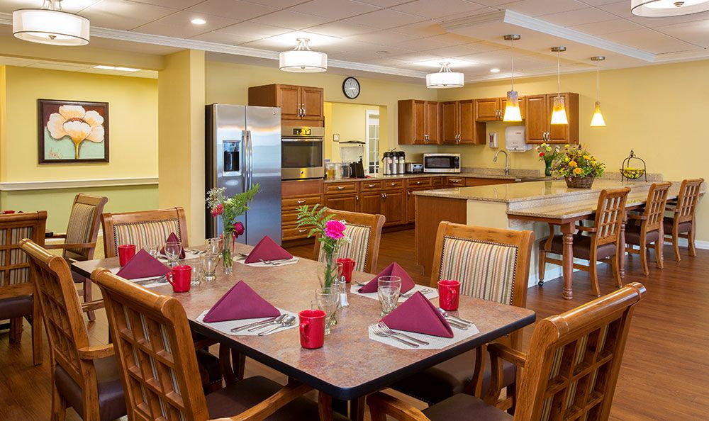 A modern kitchen and dining area with a neatly set table featuring red napkins.