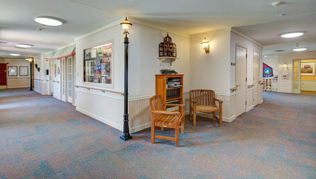 A cozy hallway corner featuring wooden chairs and a decorative lamp post.
