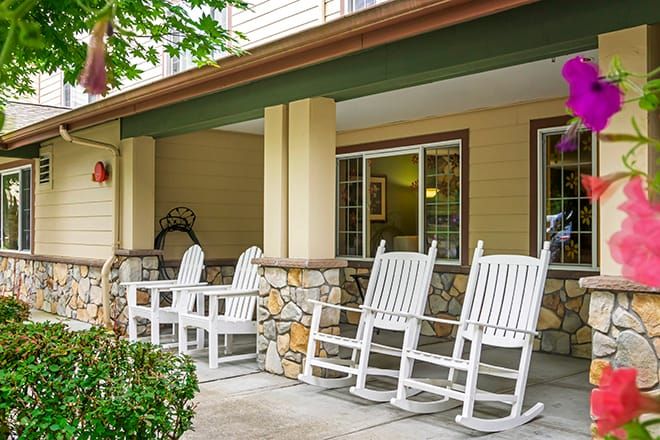 A cozy porch featuring white rocking chairs ideal for relaxation.