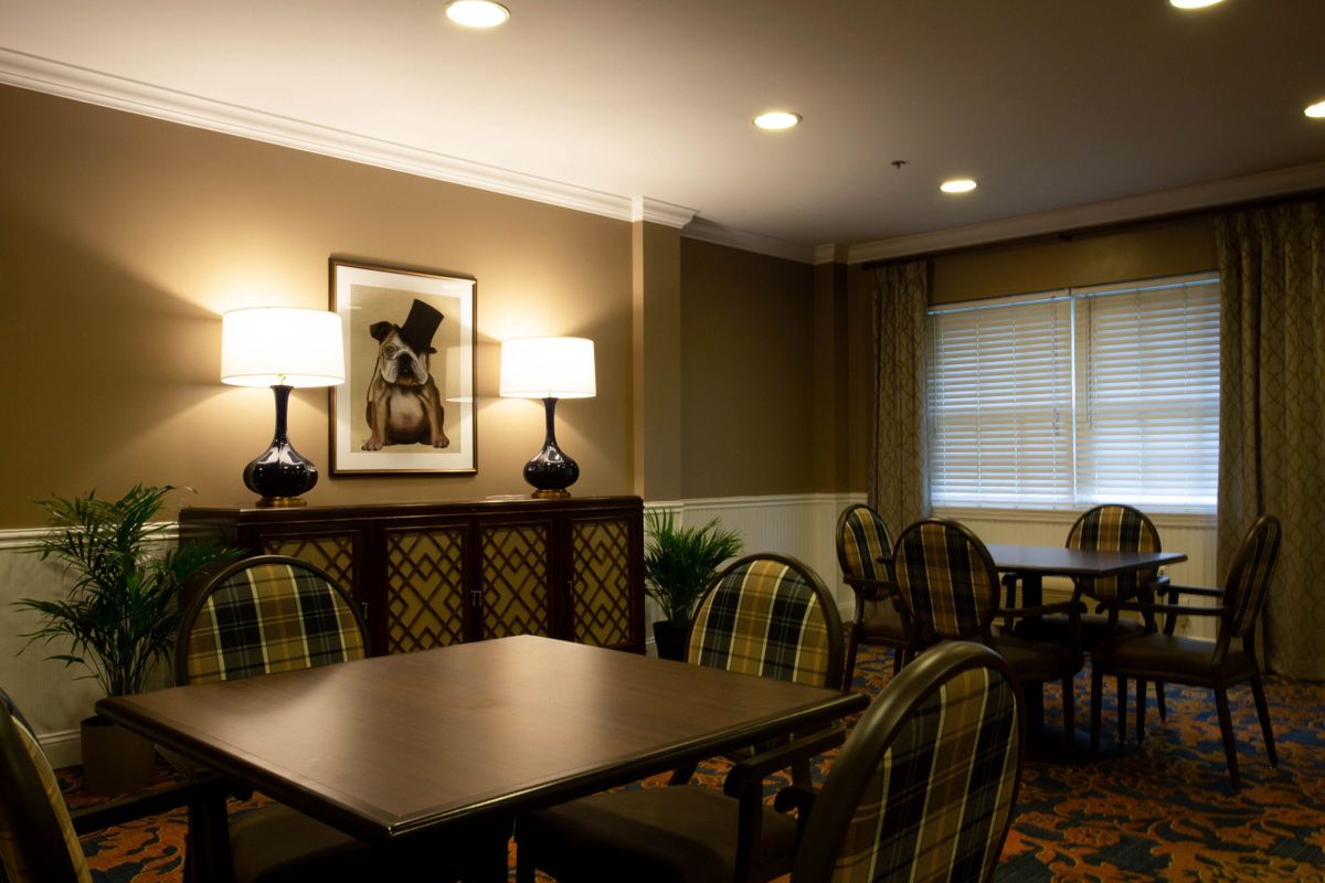 A cozy dining area with tables, chairs, and warm lighting.