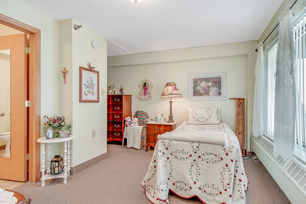 A cozy bedroom with vintage decor and a single bed adorned with a lace coverlet.
