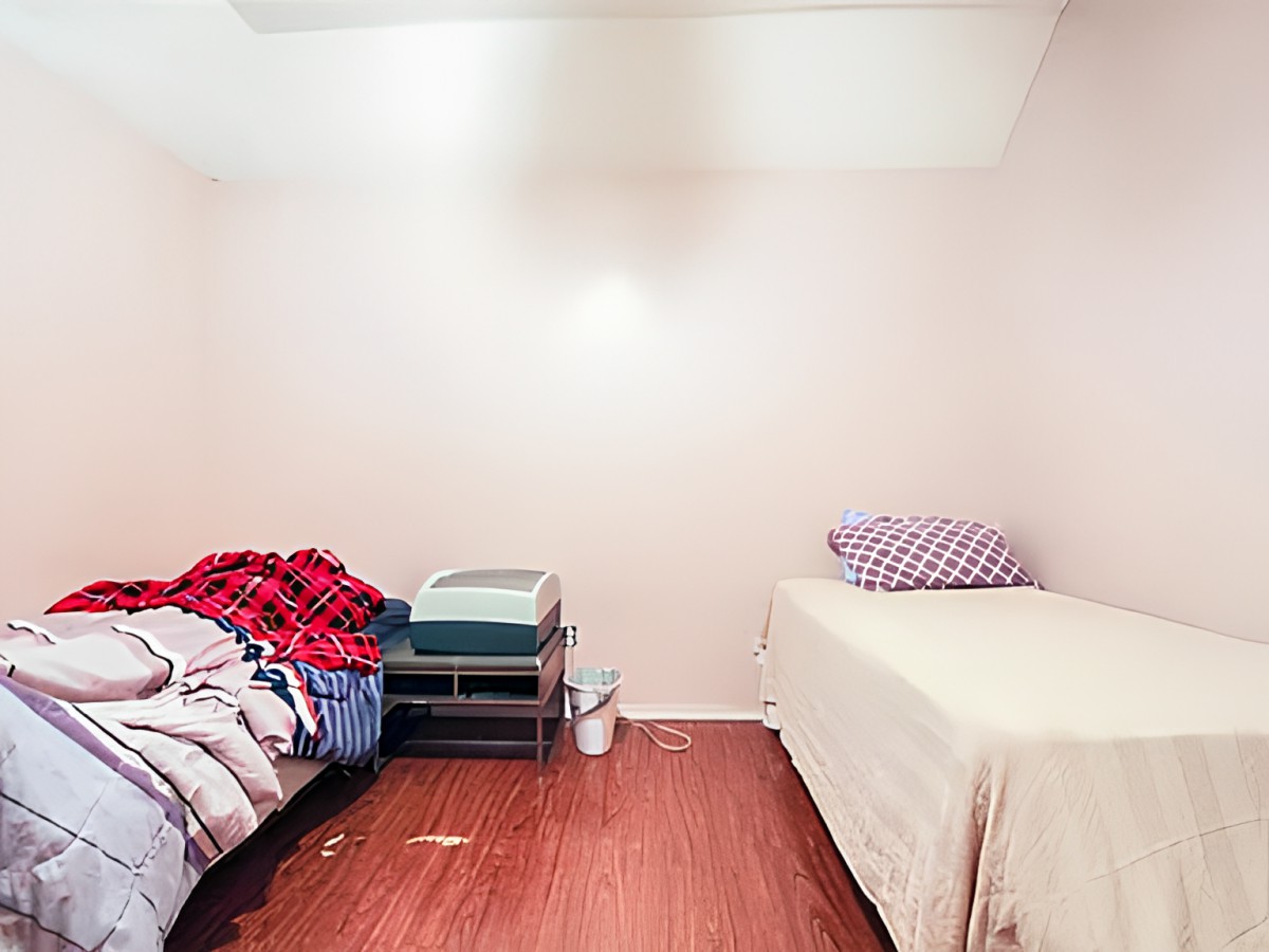 A minimalist bedroom featuring two single beds with simple bedding.