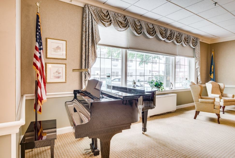 A well-decorated room with a grand piano and large windows.